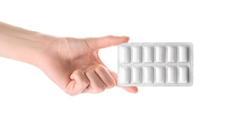 Photo of Woman holding blister with chewing gums on white background, closeup