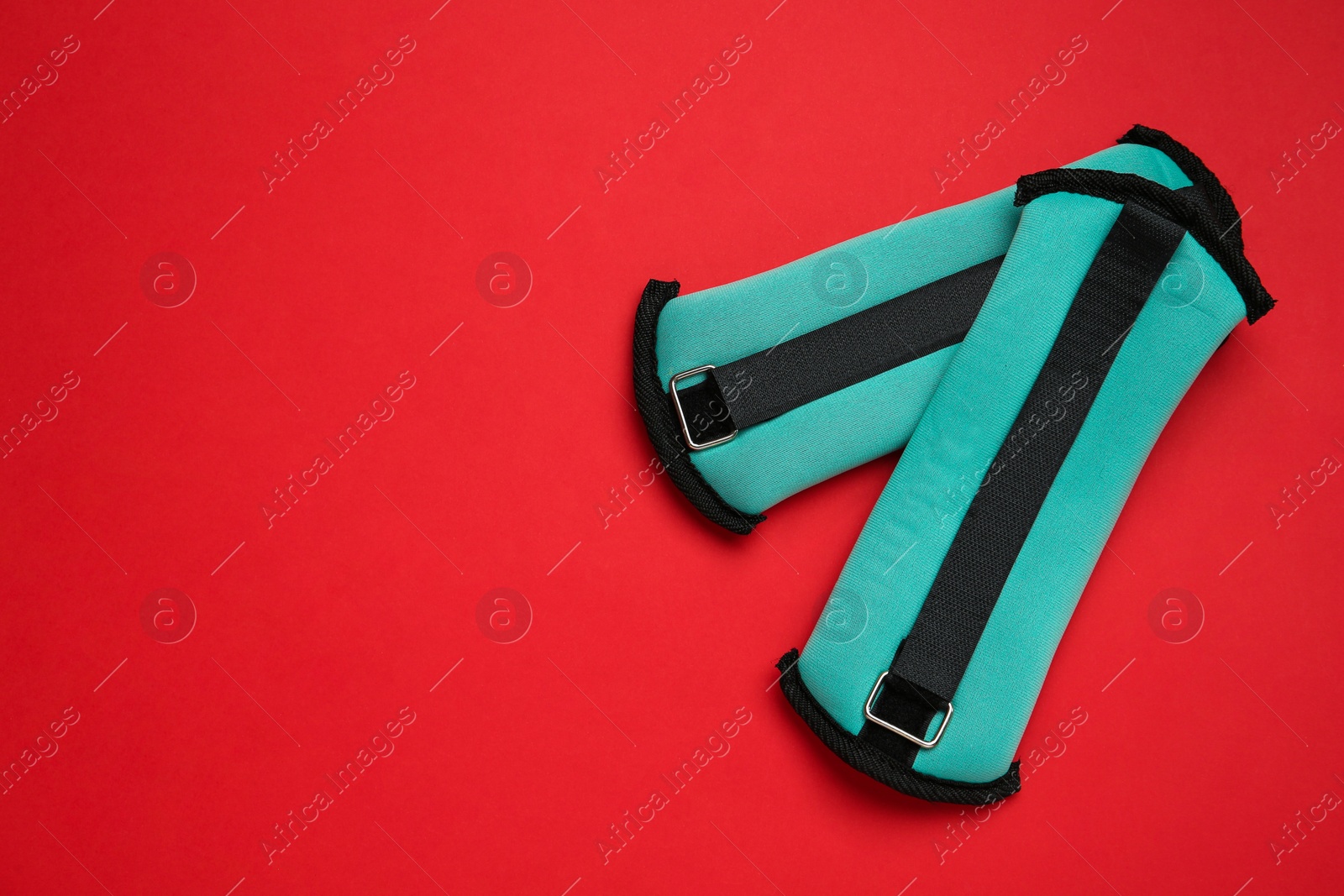 Photo of Turquoise weighting agents on red background, flat lay. Space for text