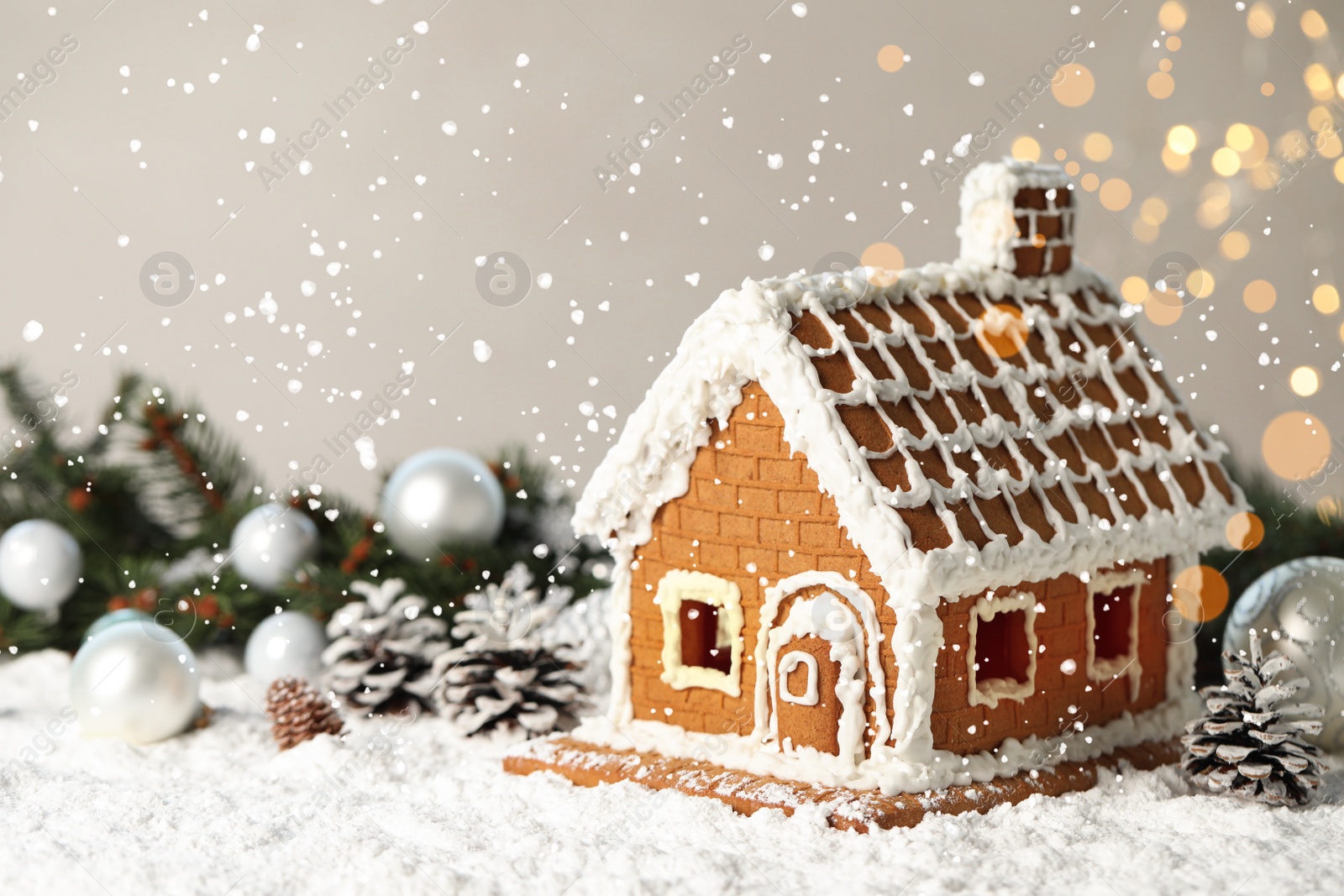 Photo of Beautiful gingerbread house decorated with icing on snow, space for text