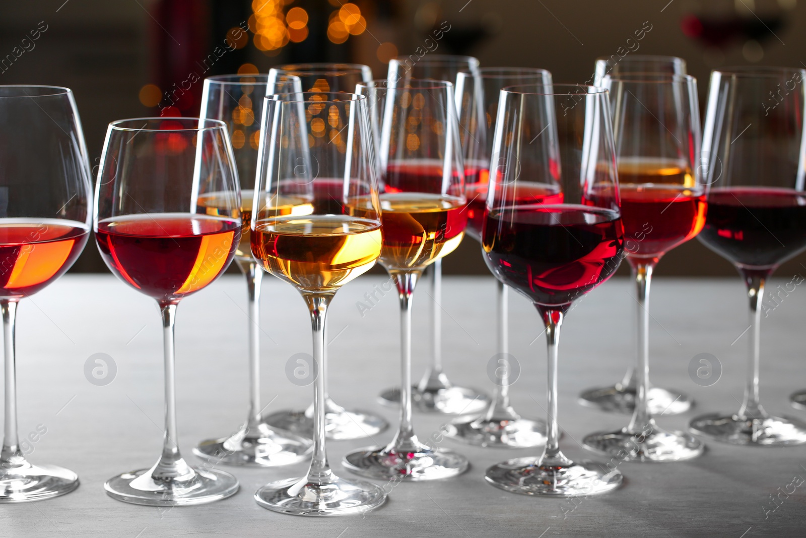 Photo of Group of glasses with different wines on table against blurred background