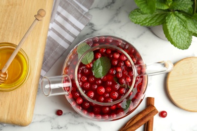 Photo of Flat lay composition with tasty hot cranberry tea and fresh ingredients on white marble table