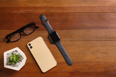 Photo of Flat lay composition with stylish smart watch on wooden table. Space for text