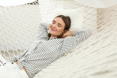 Photo of Happy woman lying in hammock at home