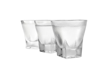 Vodka in shot glasses on white background