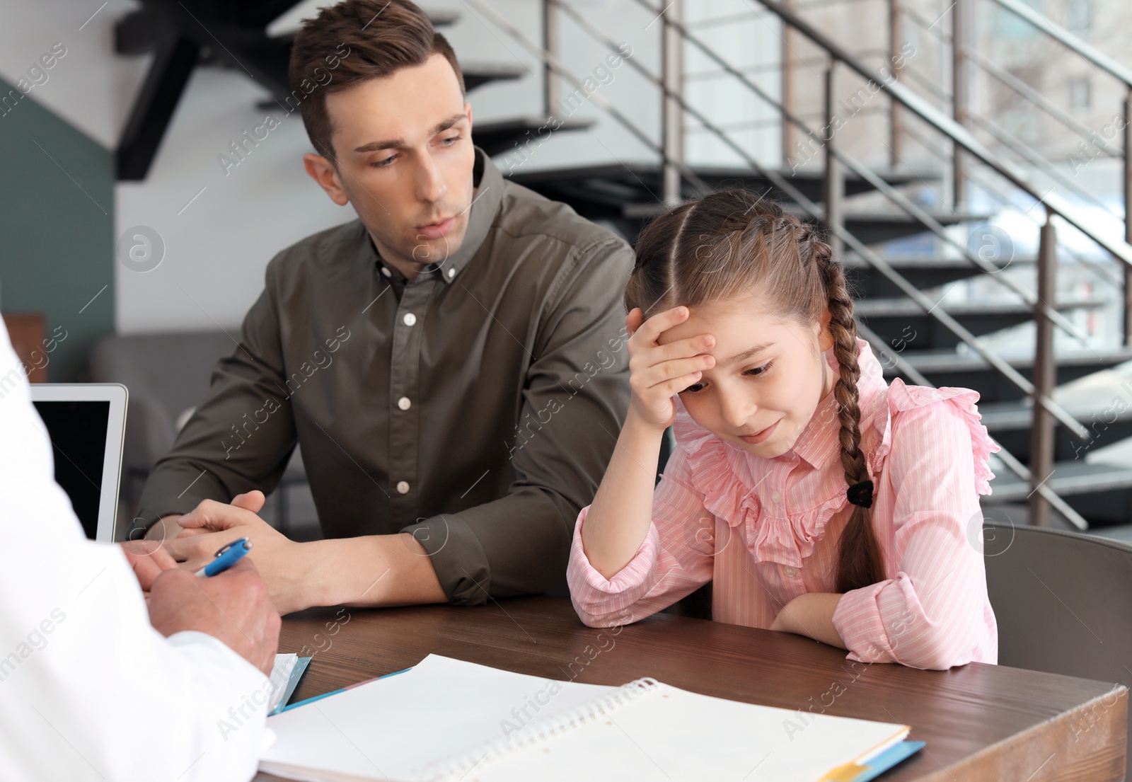 Photo of Young man with his daughter having appointment at child psychologist office