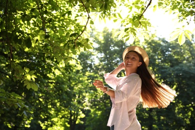 Photo of Young woman in park on sunny day, space for text