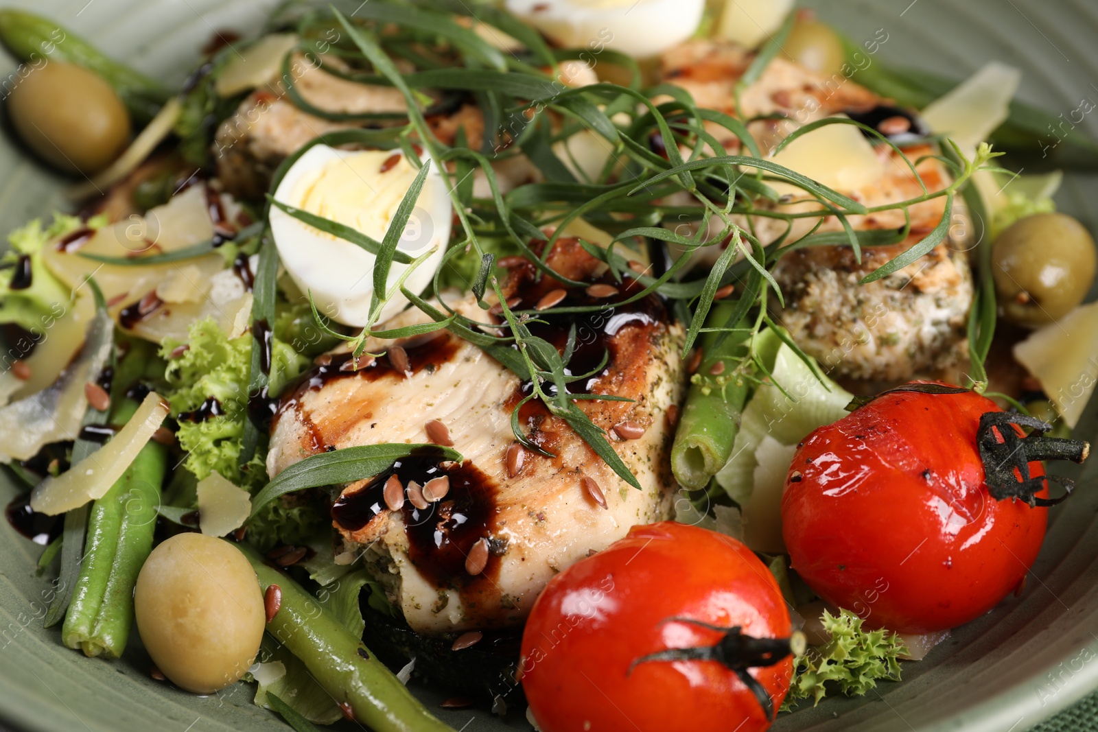 Photo of Tasty chicken, boiled egg and vegetables with tarragon in plate, closeup