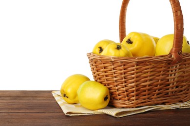 Basket with delicious fresh ripe quinces on wooden table against white background, space for text