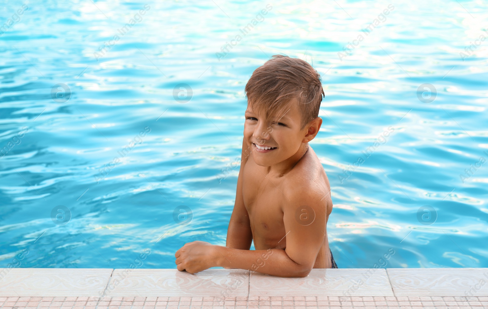 Photo of Happy cute boy in swimming pool on sunny day