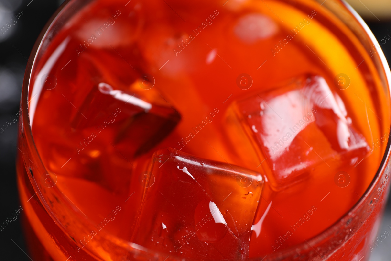 Photo of Tasty Aperol spritz cocktail with ice cubes in glass, closeup