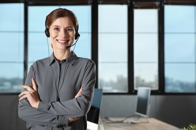 Female technical support operator with headset in office. Space for text
