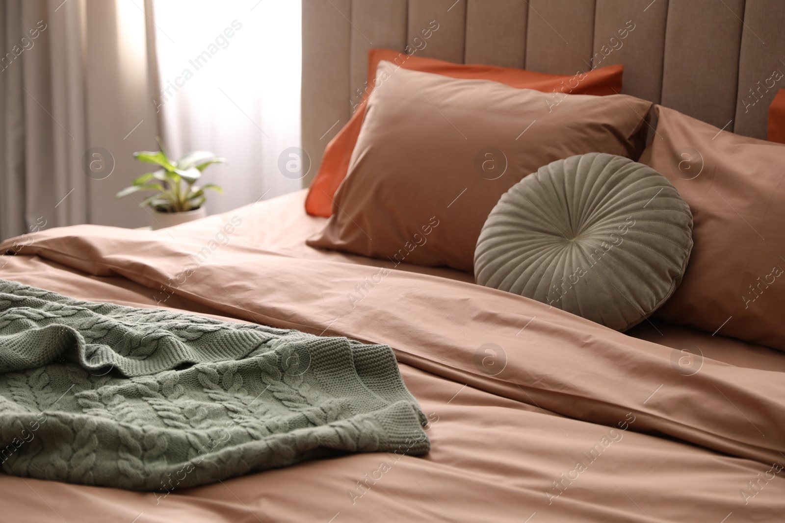 Photo of Bed with stylish cotton linens in room