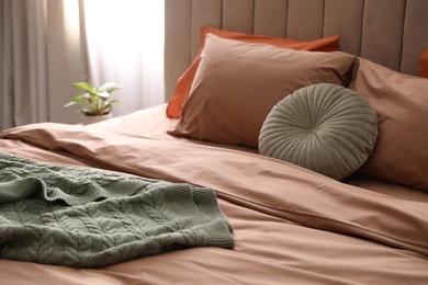 Bed with stylish cotton linens in room