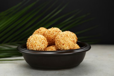 Photo of Many delicious sesame balls on textured table