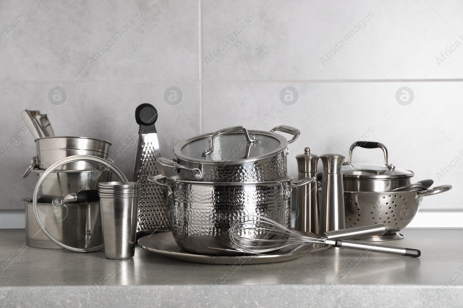 Photo of Set of different cooking utensils on grey countertop in kitchen