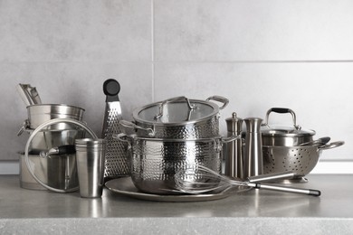 Photo of Set of different cooking utensils on grey countertop in kitchen