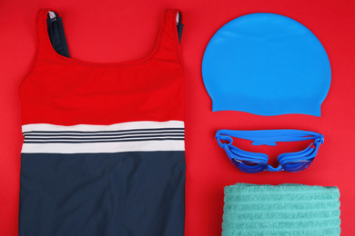 Photo of Flat lay composition with swimming accessories on red background