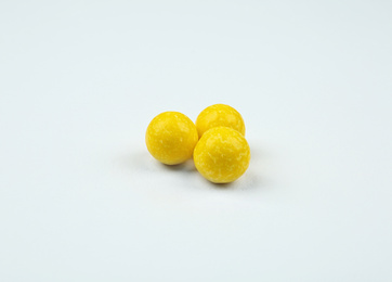 Photo of Delicious lemon chewing gums on white background