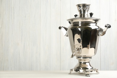 Photo of Traditional Russian samovar on white wooden background. Space for text