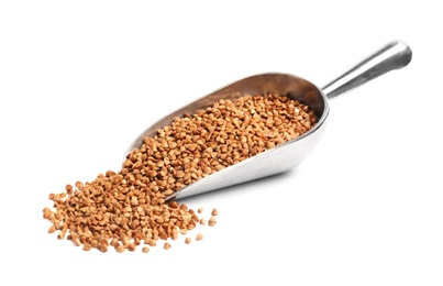 Scoop with uncooked buckwheat on white background