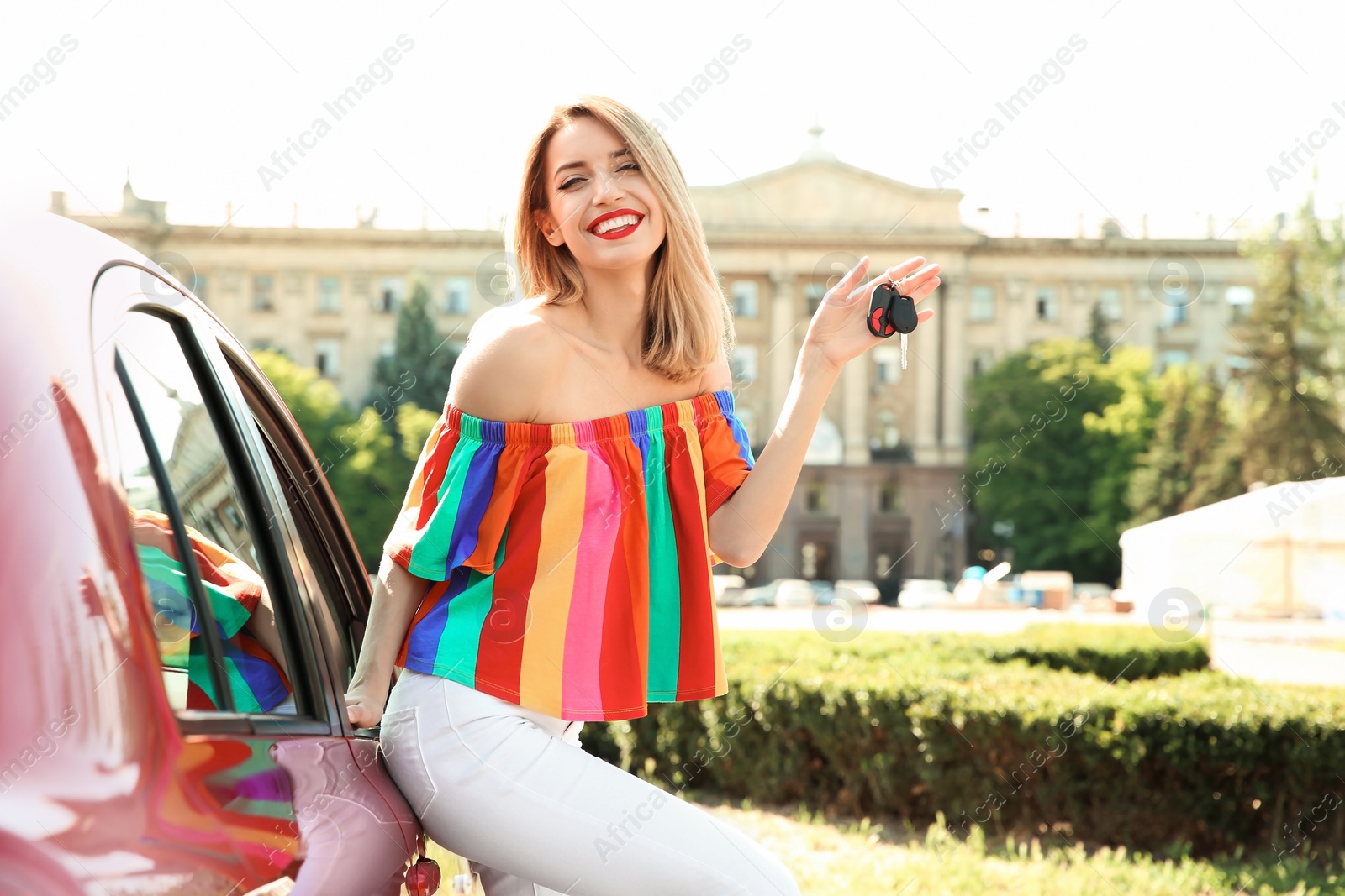 Photo of Young woman with car key near automobile outdoors