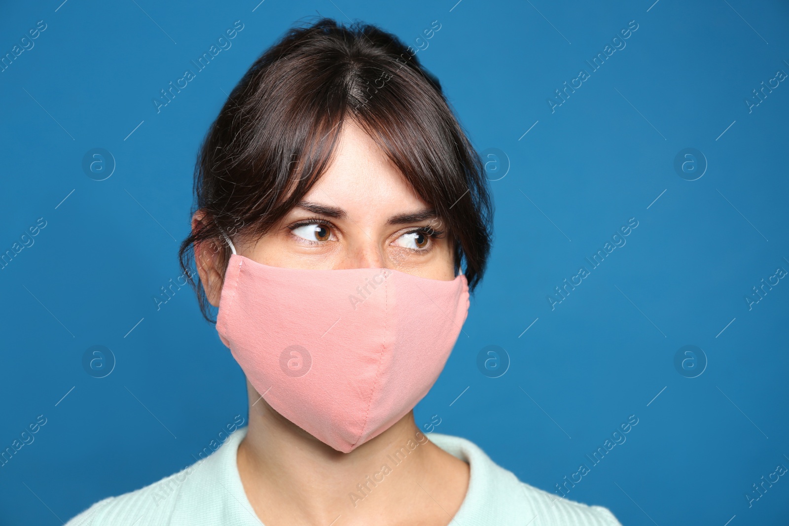Photo of Young woman in protective face mask on blue background