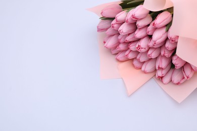 Bouquet of beautiful pink tulips on light grey background, above view. Space for text