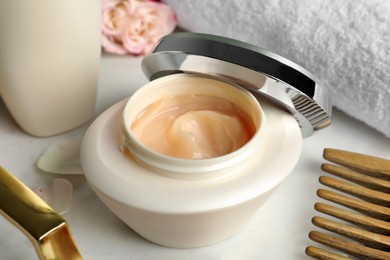 Photo of Open jar of hair care cosmetic product on white table