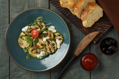 Photo of Flat lay composition with delicious grilled zucchini slices on wooden table