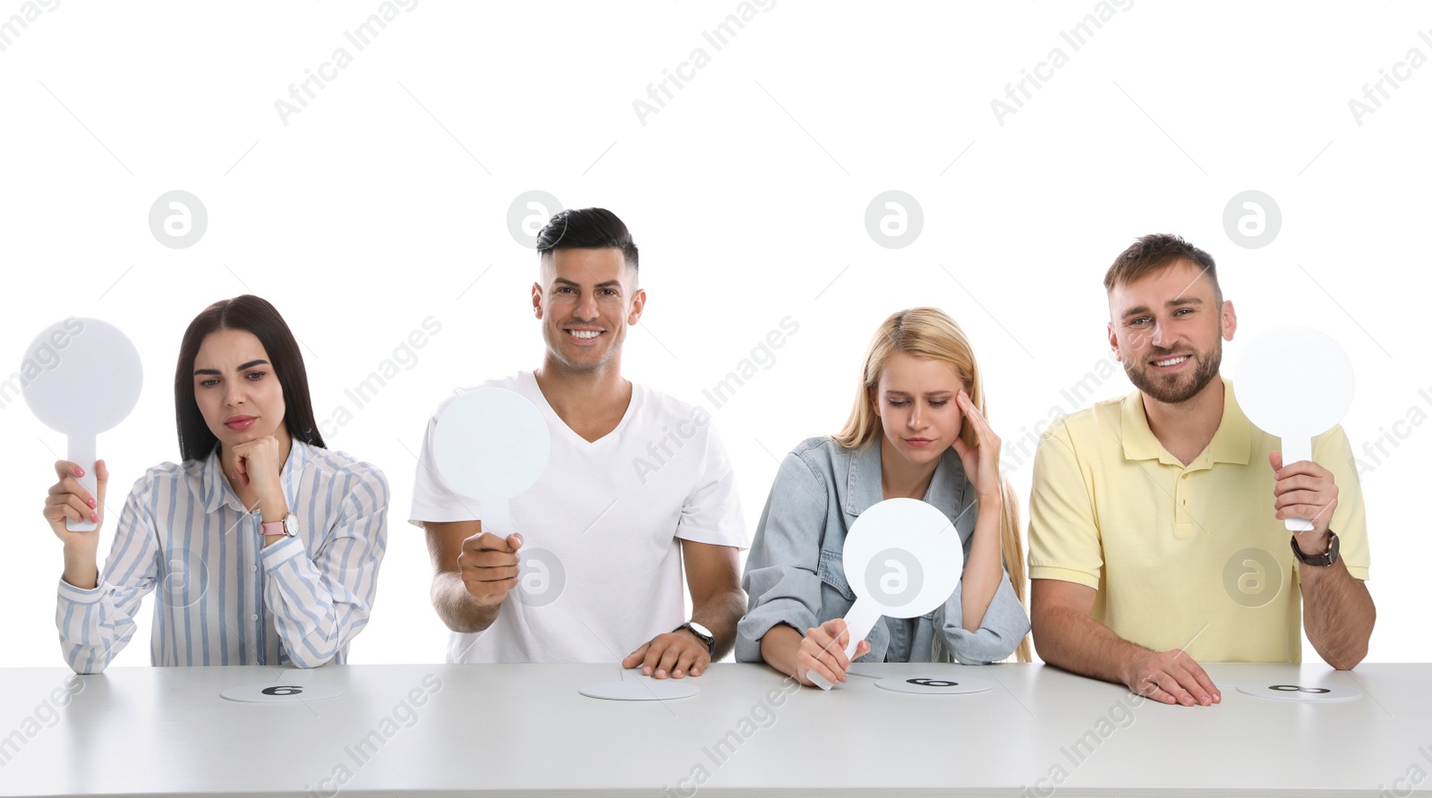 Photo of Panel of judges with different emotions holding blank signs at table on white background. Space for text
