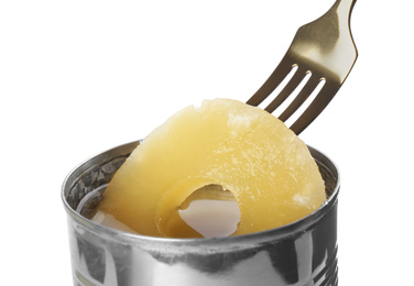 Taking canned pineapple ring from tin with fork on white background, closeup