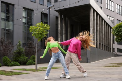 Photo of Beautiful young women dancing hip hop outdoors