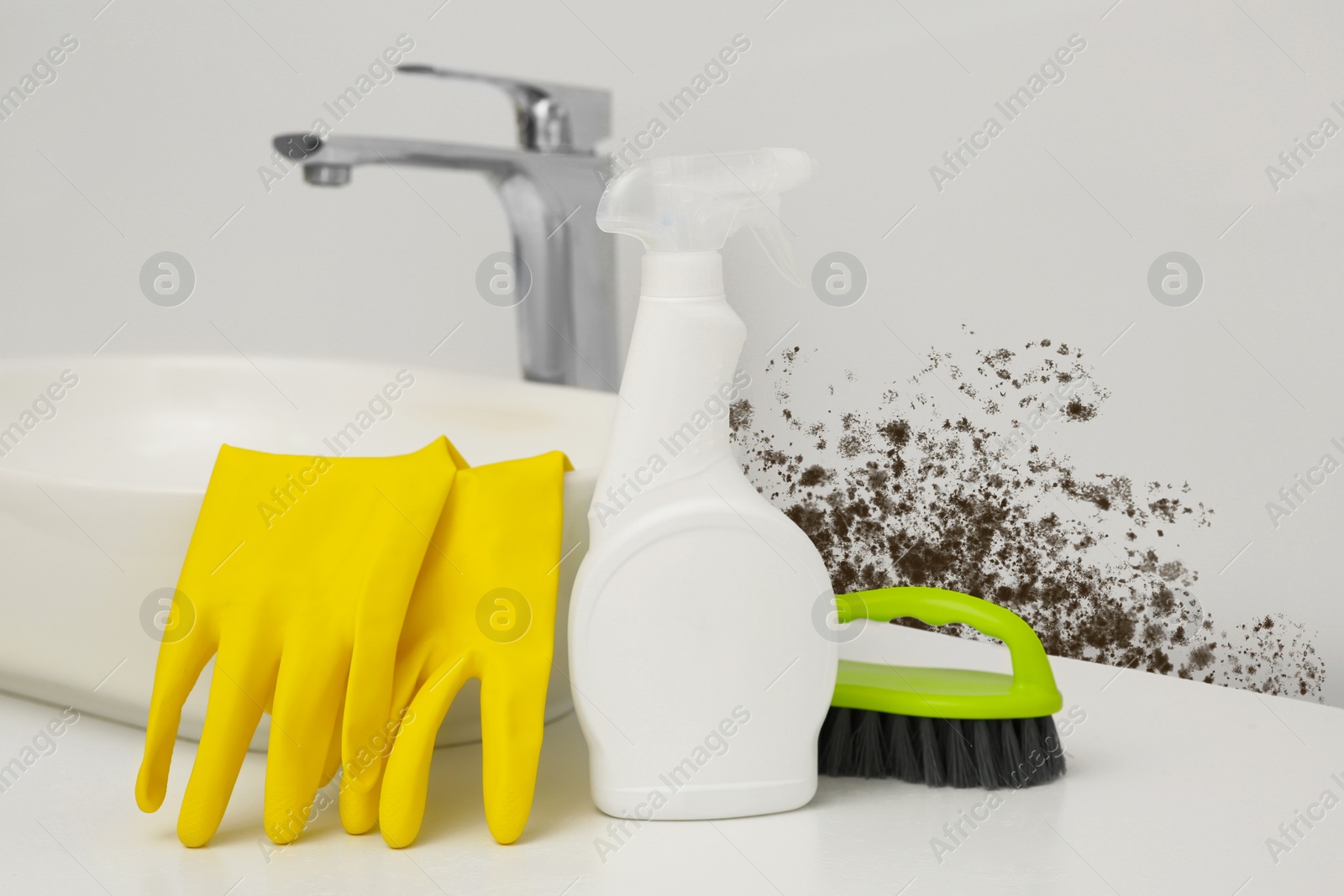 Image of Sink with rubber gloves, mold remover spray bottle and brush near affected wall in bathroom