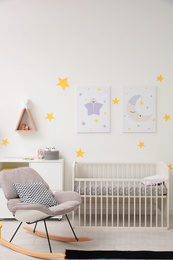 Photo of Stylish baby room interior with crib and rocking chair