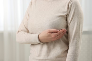 Photo of Mammology. Young woman doing breast self-examination at home, closeup