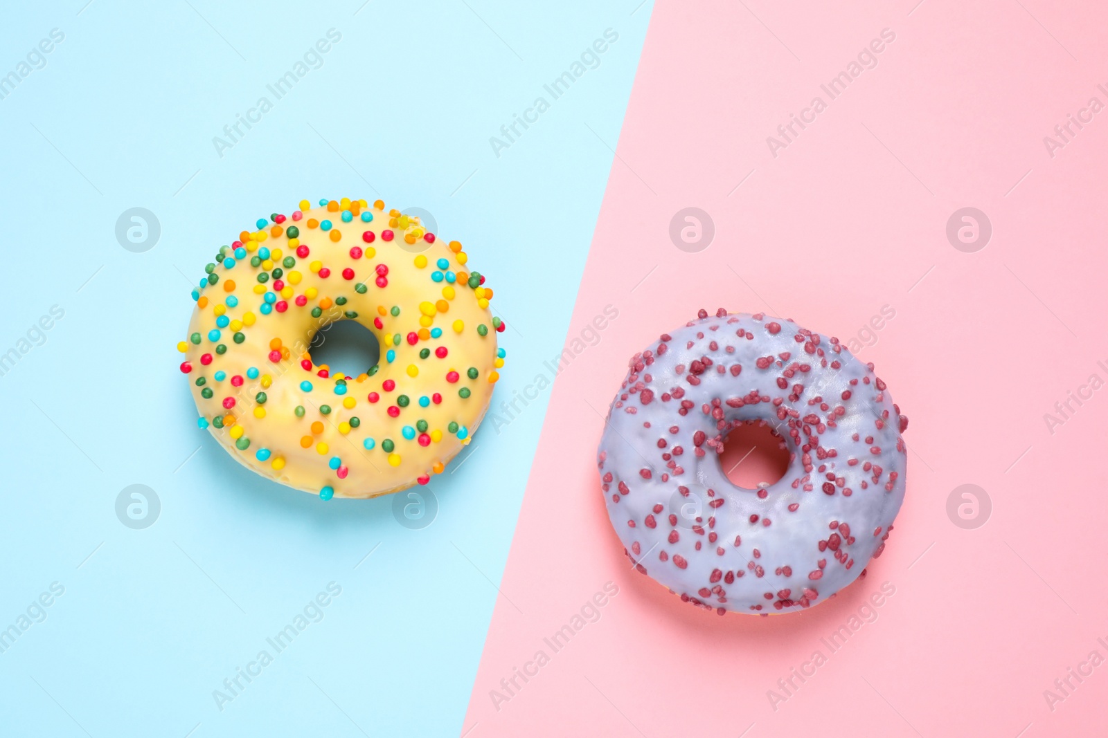Photo of Delicious glazed donuts on color background, flat lay