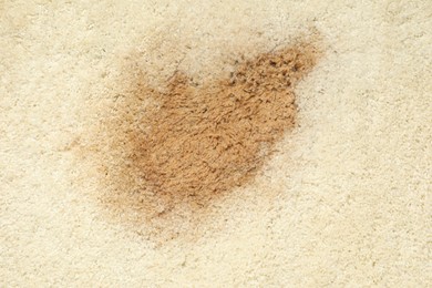 Photo of Wet spot on beige carpet as background, top view