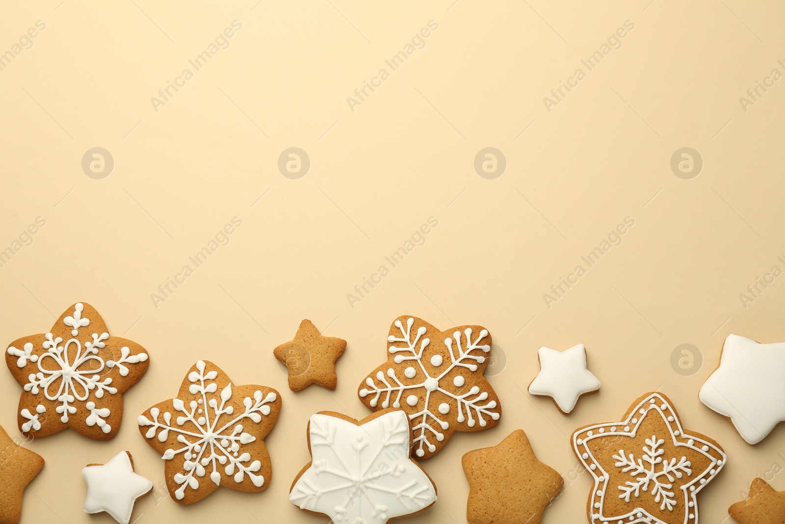 Photo of Tasty Christmas cookies with icing on beige background, flat lay. Space for text