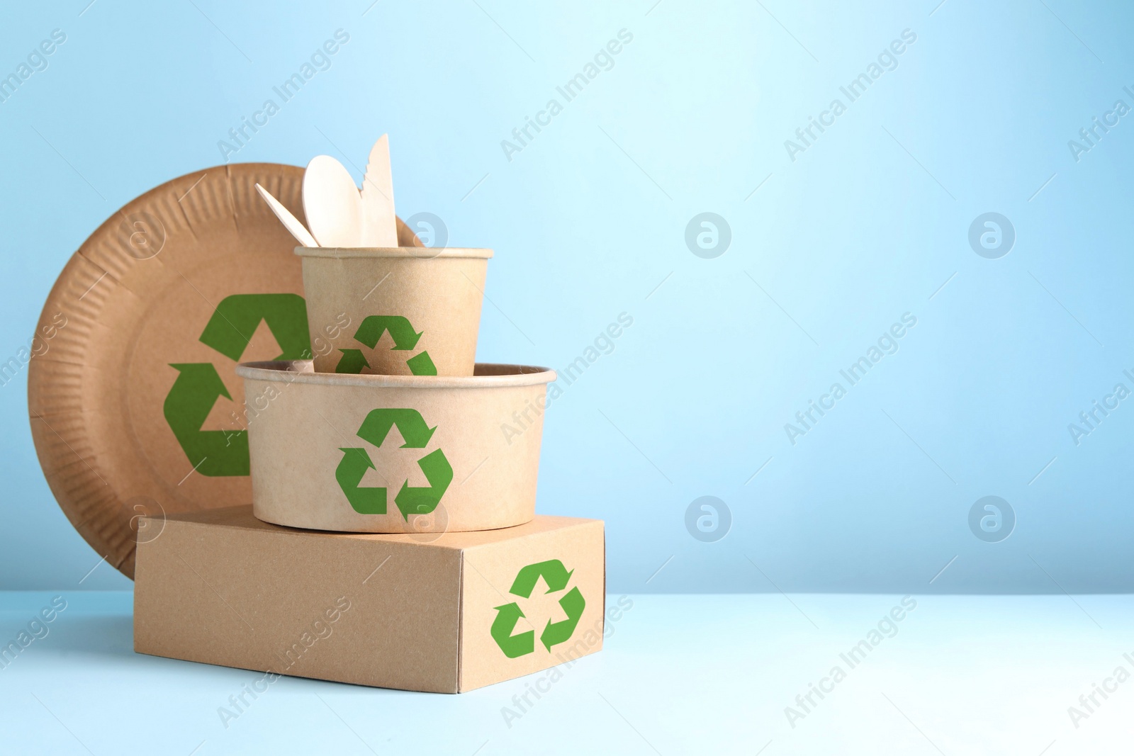 Image of Set of eco friendly food packaging with recycling symbols on light blue background. Space for text