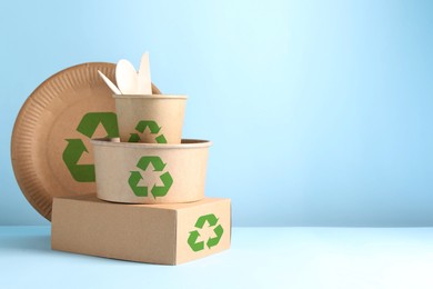 Image of Set of eco friendly food packaging with recycling symbols on light blue background. Space for text