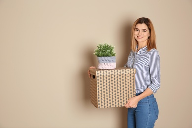 Woman with moving box and plant on color background. Space for text