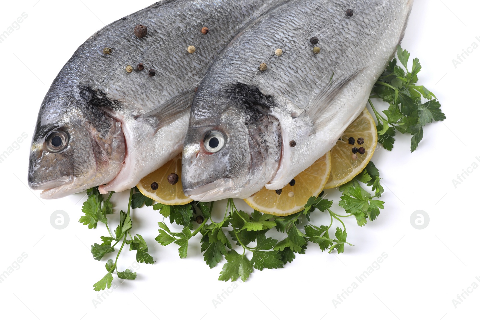 Photo of Raw dorado fish, parsley, lemon slices and peppercorns isolated on white, top view