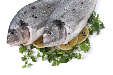 Raw dorado fish, parsley, lemon slices and peppercorns isolated on white, top view