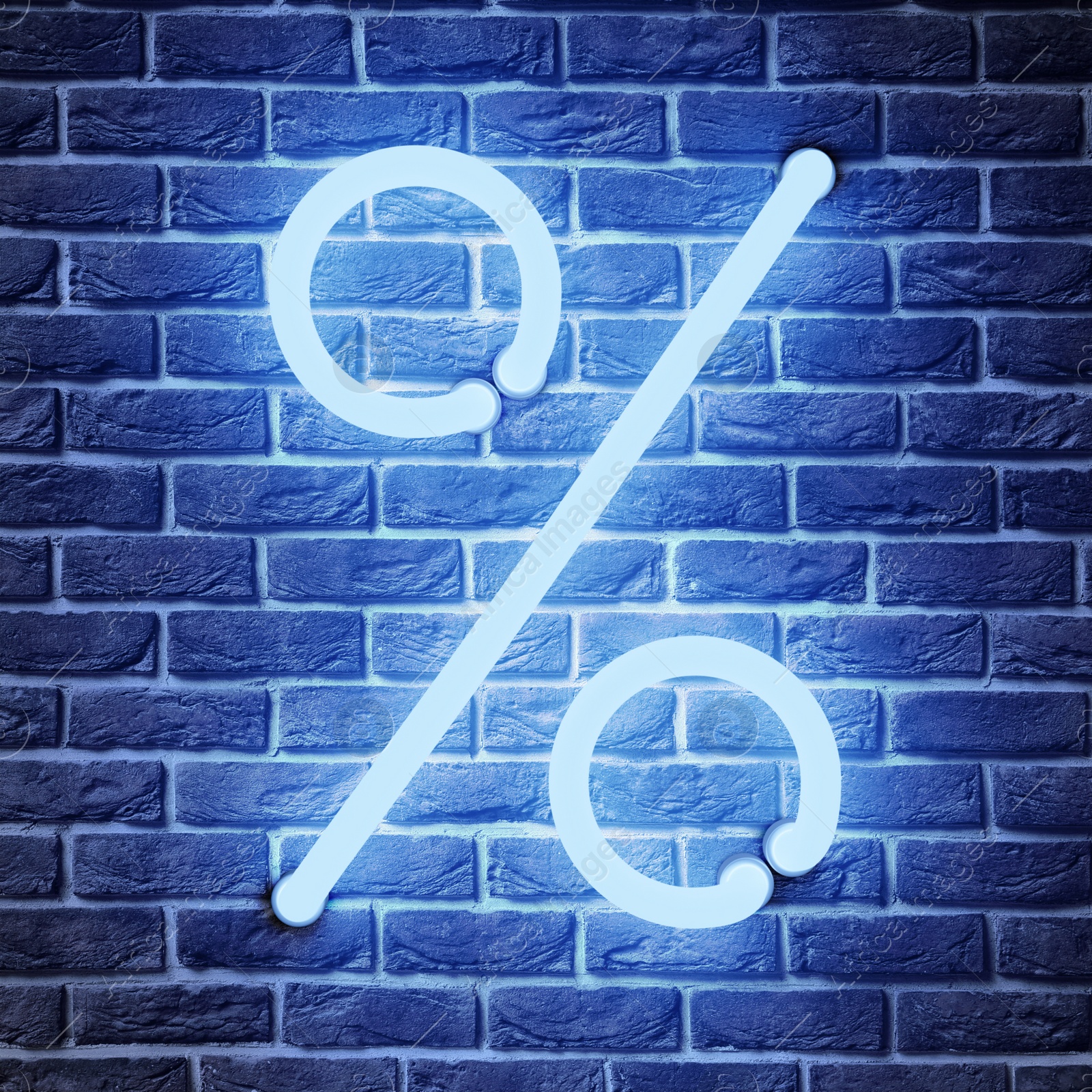 Image of Glowing neon percent sign on brick wall