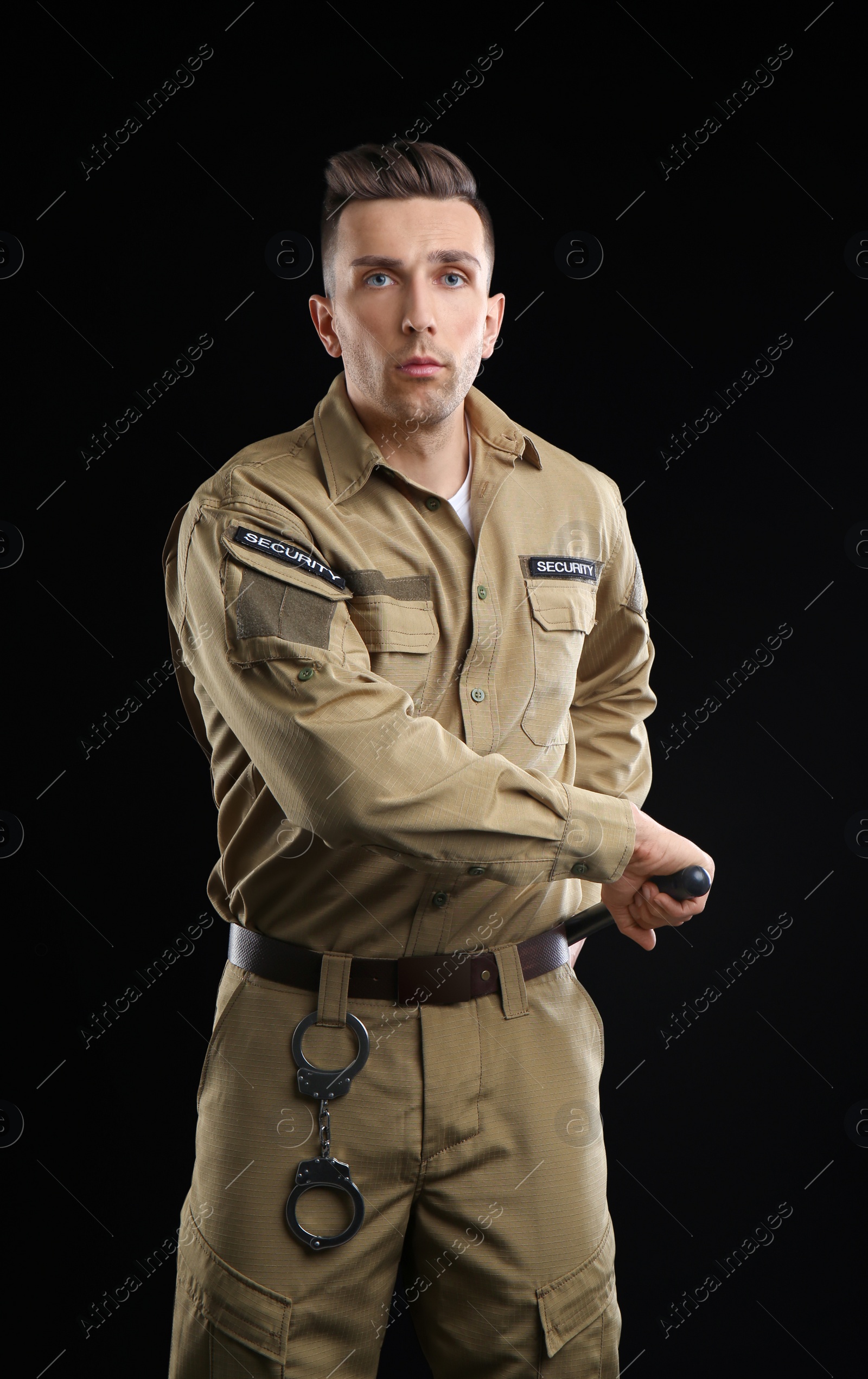 Photo of Male security guard with police baton on dark background