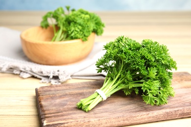 Photo of Fresh green parsley on wooden table, space for text