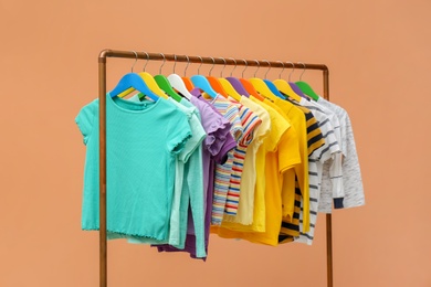 Photo of Rack with stylish children clothes on beige background