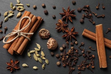 Photo of Different spices on dark gray textured table, flat lay
