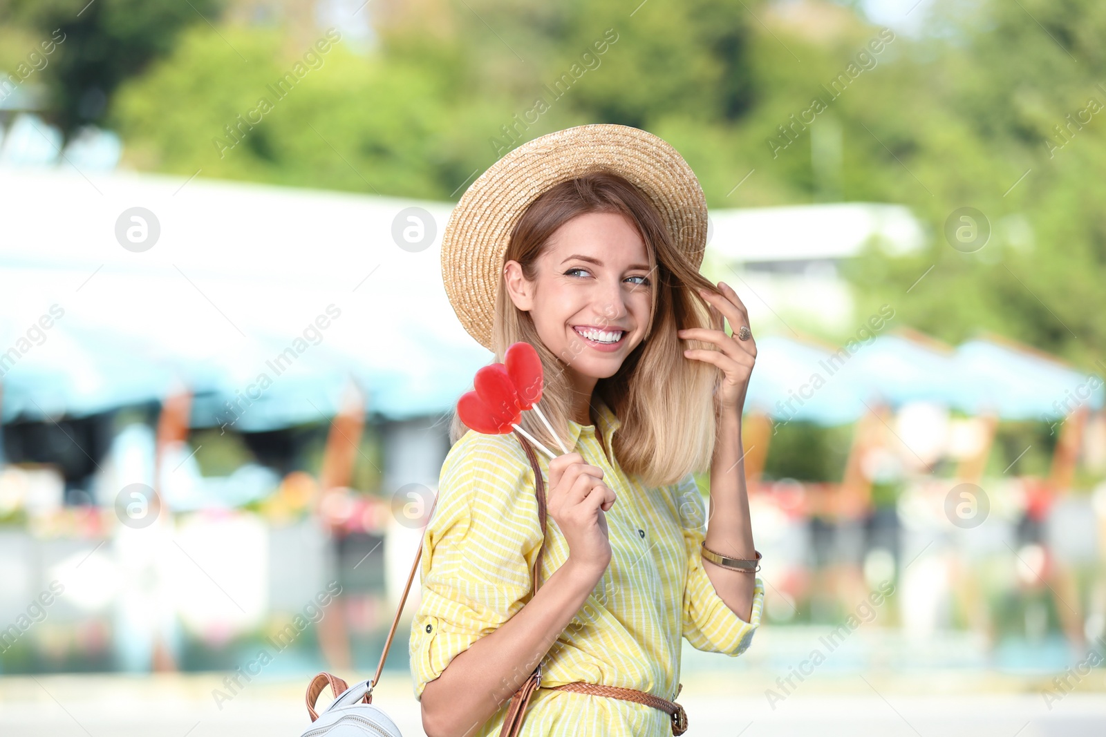 Photo of Beautiful smiling woman with candies on city street