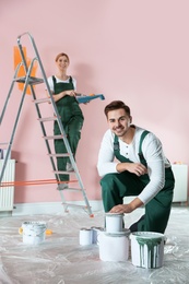 Professional decorators painting wall indoors. Home repair service